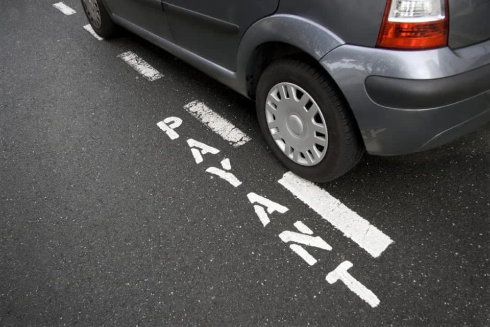 Vue d'une rue parisienne dense avec des voitures garées en file, ambiance quartier résidentiel haussmannien