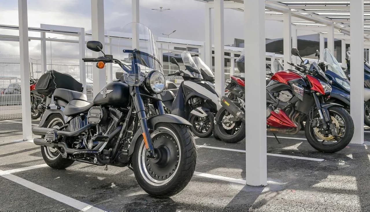 Moto garée dans un parking souterrain parisien sécurisé, vue intérieure avec arceaux et éclairage Alt text : Parking moto Paris 2026 — location mensuelle entre particuliers en sous-sol sécurisé
